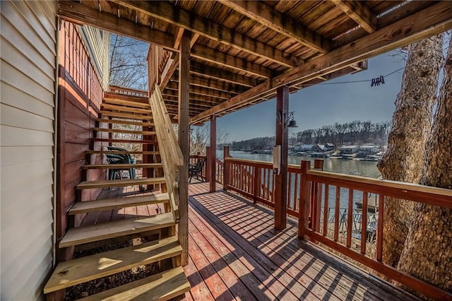 wooden terrace featuring stairway and a water view