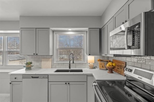 kitchen featuring a sink, plenty of natural light, gray cabinets, and stainless steel appliances