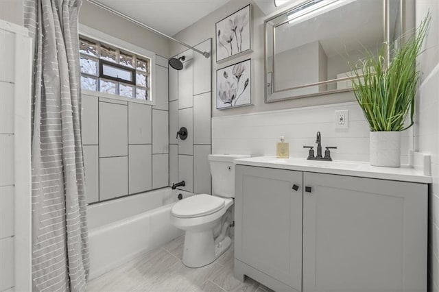 bathroom with vanity, tile walls, toilet, and shower / tub combo with curtain