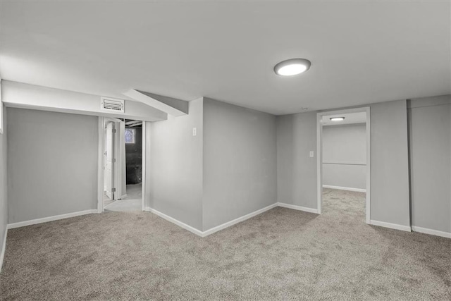 finished below grade area featuring visible vents, baseboards, and carpet floors