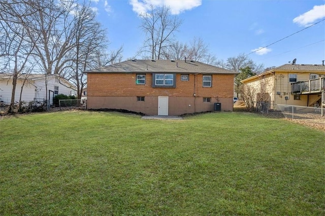 rear view of house featuring a lawn, cooling unit, and a fenced backyard