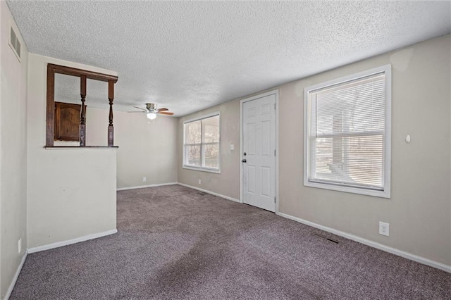 interior space with baseboards, carpet floors, a textured ceiling, and ceiling fan