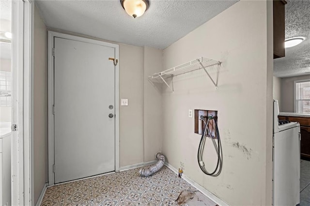 washroom with laundry area, washer / clothes dryer, a textured ceiling, and baseboards