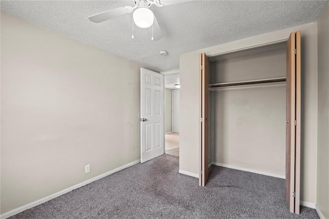 unfurnished bedroom with a ceiling fan, a textured ceiling, a closet, dark colored carpet, and baseboards