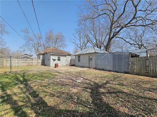 view of yard with a patio, an outbuilding, and a fenced backyard