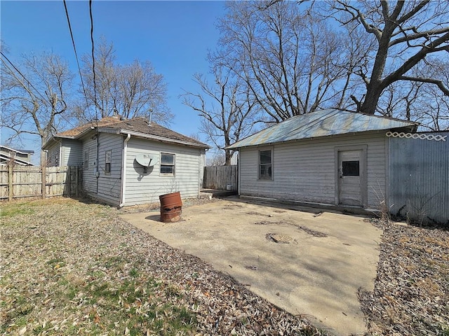 back of house with an outbuilding, a fenced backyard, and a patio