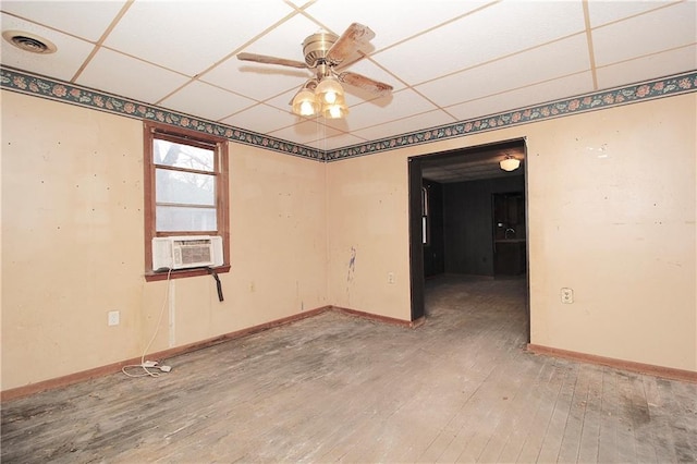 empty room featuring a drop ceiling, visible vents, baseboards, and hardwood / wood-style floors