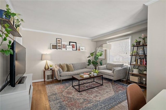 living room featuring visible vents, crown molding, baseboards, and wood finished floors