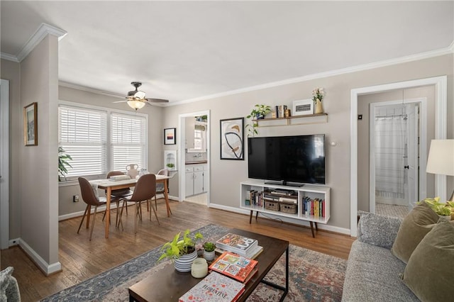 living area featuring ceiling fan, wood finished floors, baseboards, and ornamental molding