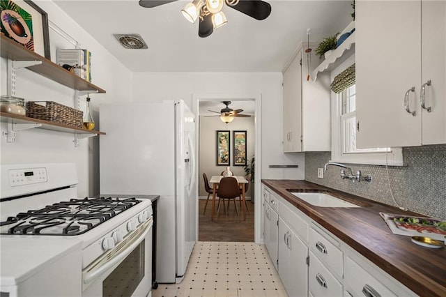 kitchen featuring a sink, butcher block counters, ceiling fan, and white gas range oven