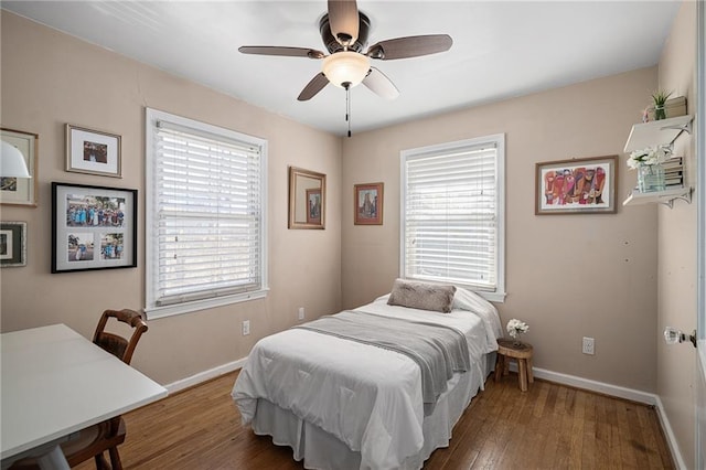 bedroom featuring ceiling fan, baseboards, and wood finished floors