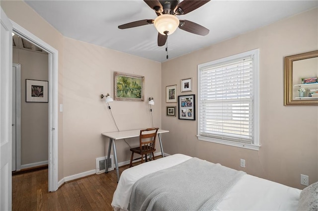 bedroom with ceiling fan, visible vents, baseboards, and wood finished floors