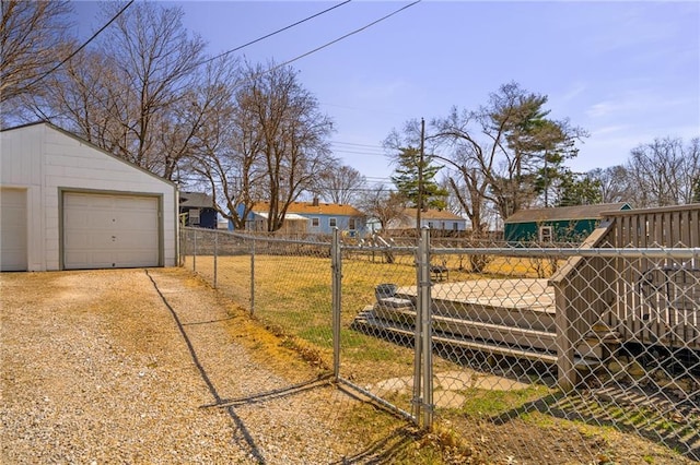 view of yard featuring a garage, an outbuilding, and fence