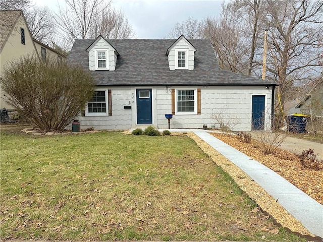 cape cod house featuring a front yard and roof with shingles