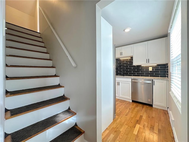 stairs featuring recessed lighting and wood finished floors