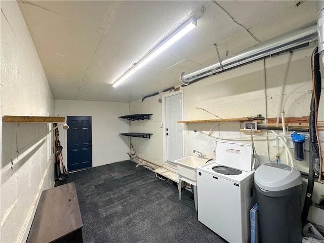 clothes washing area featuring laundry area, washer / dryer, and a sink