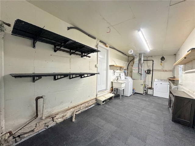 basement featuring heating unit, washing machine and dryer, and a sink