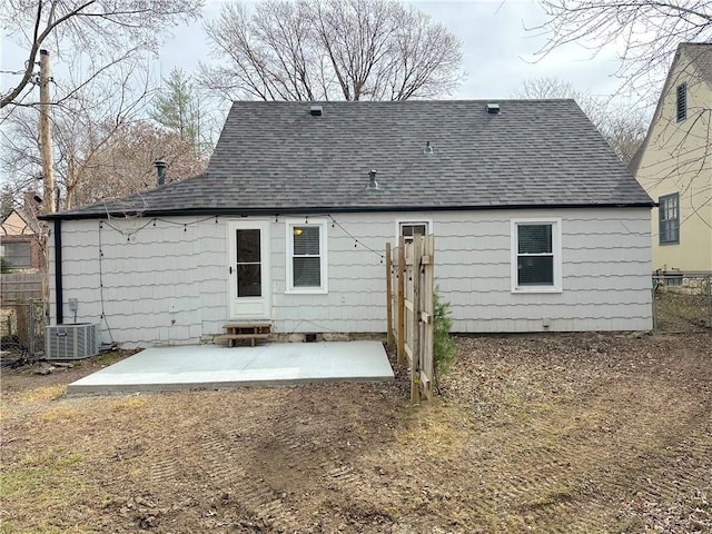 rear view of property with entry steps, a patio, central AC, fence, and roof with shingles