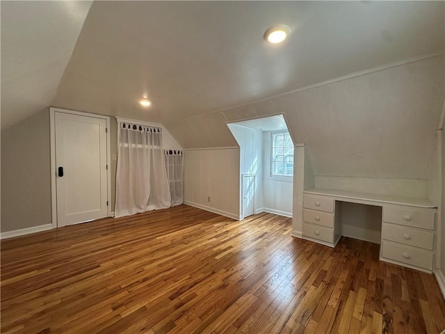 bonus room with baseboards, hardwood / wood-style floors, and vaulted ceiling