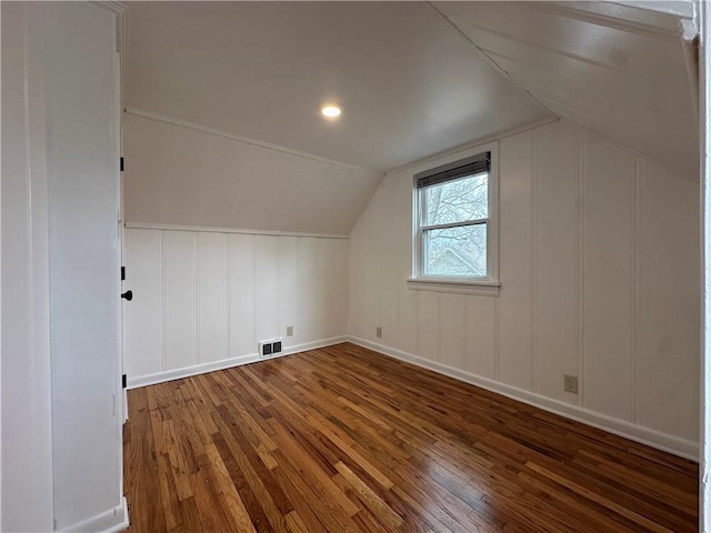 additional living space featuring visible vents, lofted ceiling, and hardwood / wood-style flooring