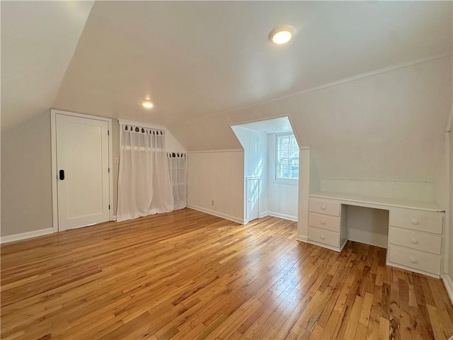 bonus room featuring baseboards, vaulted ceiling, and light wood finished floors