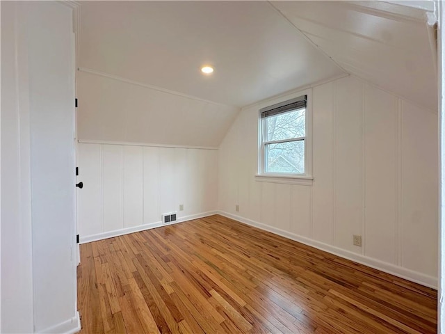 bonus room featuring visible vents, light wood-type flooring, and vaulted ceiling