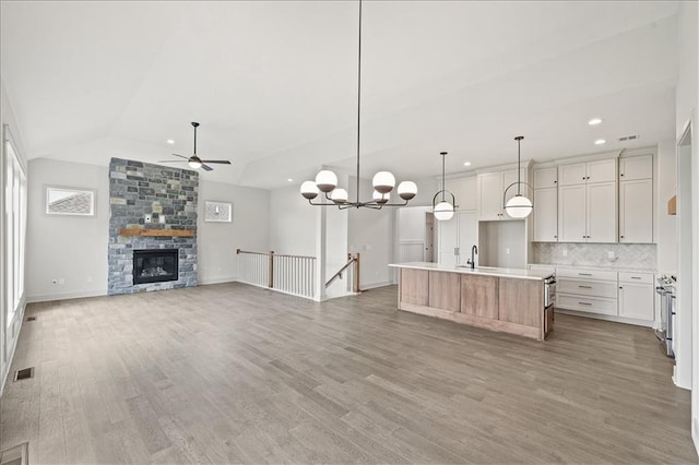 kitchen featuring a ceiling fan, visible vents, light countertops, open floor plan, and backsplash