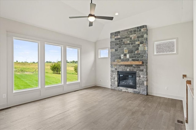 unfurnished living room featuring baseboards, ceiling fan, lofted ceiling, a fireplace, and wood finished floors