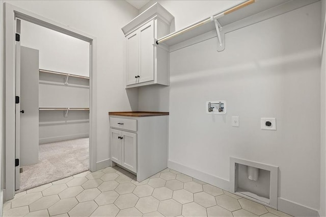 washroom with cabinet space, hookup for a washing machine, electric dryer hookup, and baseboards