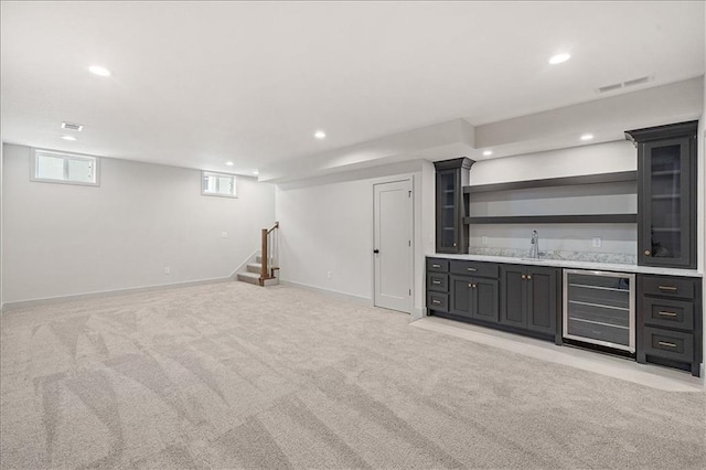 interior space with wet bar, wine cooler, recessed lighting, and light colored carpet