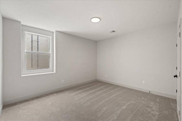 carpeted spare room with visible vents and baseboards