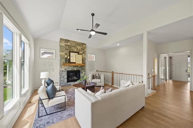 22109 W 80th Ter, Shawnee, KS 66220 - living room featuring lofted ceiling, a stone fireplace, light wood-type flooring, and a ceiling fan