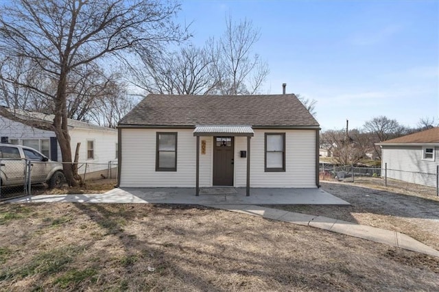 bungalow-style home with fence and a shingled roof