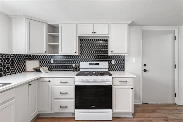 kitchen featuring open shelves, light countertops, gas range oven, white cabinetry, and backsplash