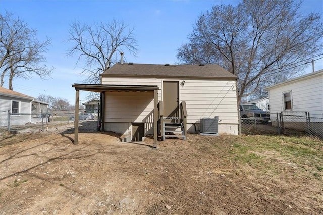 rear view of property with entry steps, a gate, fence, and central AC