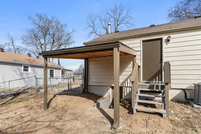 exterior space with a gate, entry steps, central AC, and fence