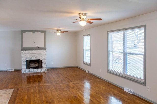 unfurnished living room featuring visible vents, ceiling fan, baseboards, and wood finished floors