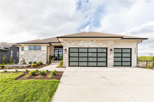 prairie-style house with stucco siding, stone siding, concrete driveway, and an attached garage