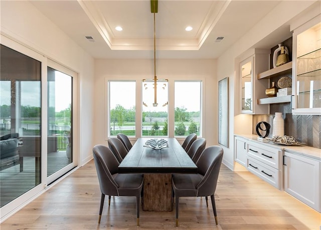 dining room with light wood finished floors, visible vents, recessed lighting, and a raised ceiling