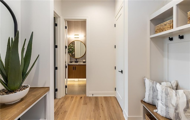 mudroom featuring a sink and light wood finished floors