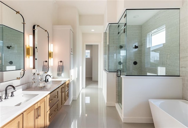 bathroom with a freestanding bath, a shower stall, double vanity, and a sink