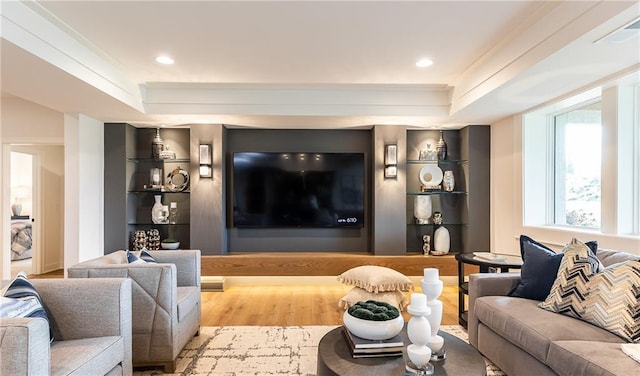 living room featuring visible vents, built in features, a tray ceiling, recessed lighting, and wood finished floors