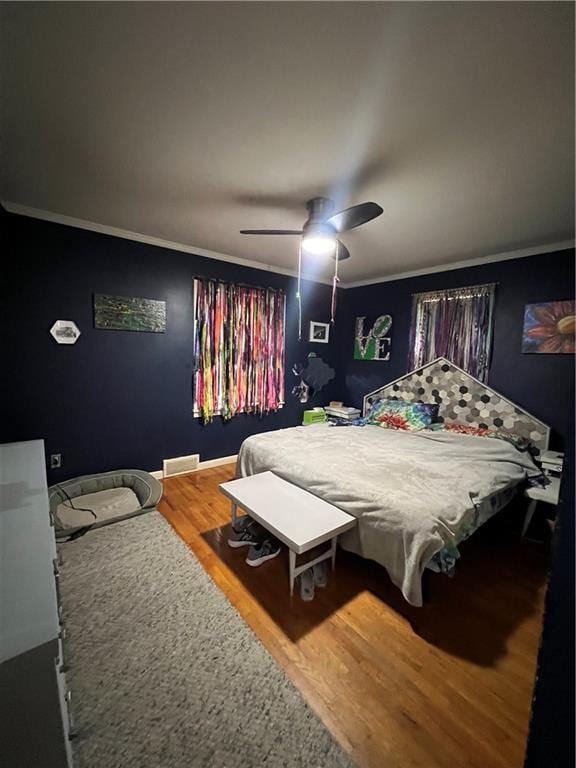 bedroom featuring ornamental molding, ceiling fan, and wood finished floors