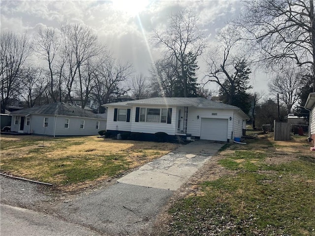 view of front facade featuring a garage, concrete driveway, and a front yard