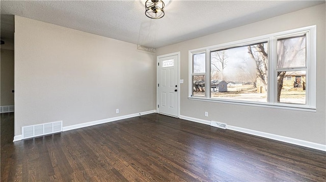 entryway featuring wood finished floors, a healthy amount of sunlight, visible vents, and baseboards