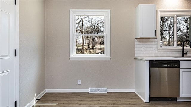 kitchen with visible vents, baseboards, stainless steel dishwasher, and decorative backsplash