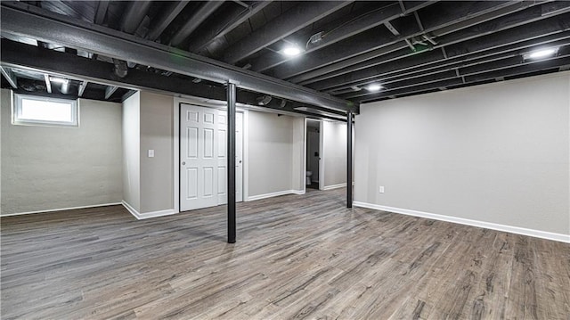 below grade area featuring wood finished floors and baseboards