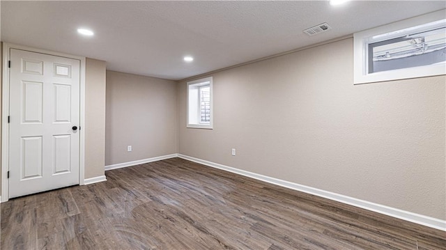 basement featuring visible vents, a textured ceiling, wood finished floors, recessed lighting, and baseboards