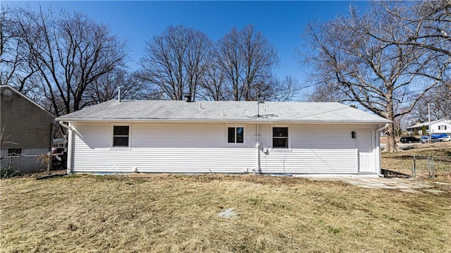 rear view of property featuring a yard and fence