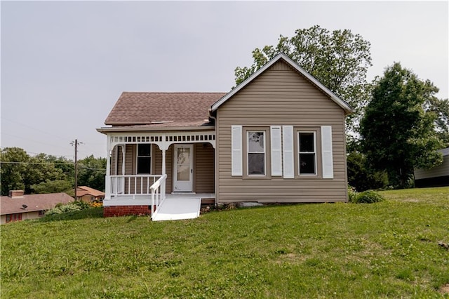 713 N 13th St, Atchison, KS 66002 - view of front of home with covered porch, a front lawn, and roof with shingles
